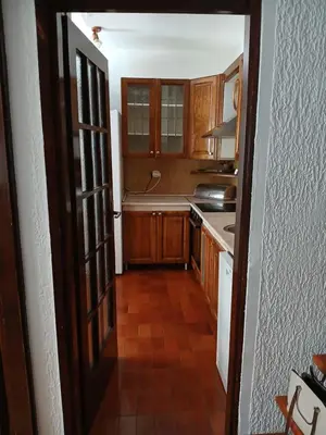 a kitchen with wooden cabinets and a door open at Apartment Icemoon in Kotor