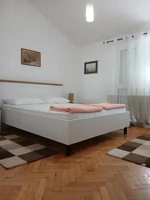 a white bed in a room with a wooden floor at Apartment Icemoon in Kotor