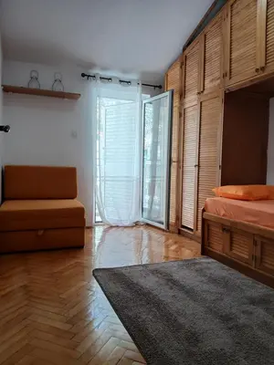 a bedroom with a bed and a chair and a window at Apartment Icemoon in Kotor
