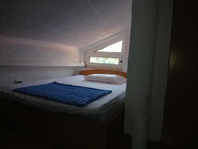 a small bed in a room with a window at Apartment Icemoon in Kotor