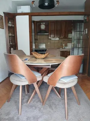 a dining room table with four chairs and a kitchen at Apartment Icemoon in Kotor