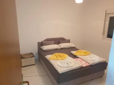 a bed with two yellow pillows on it in a room at Apartmani Gusani in Radanovići