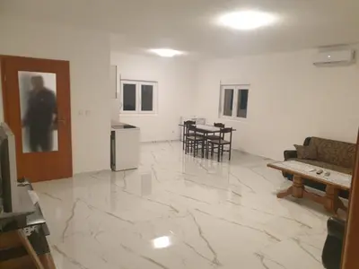 a living room with a marble floor and a couch at Apartmani Gusani in Radanovići
