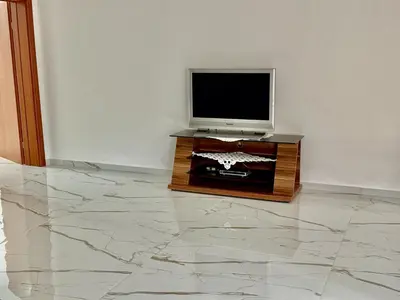 a television sitting on a table with a marble floor at Apartmani Gusani in Radanovići