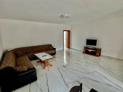 a living room with a couch and a television at Apartmani Gusani in Radanovići