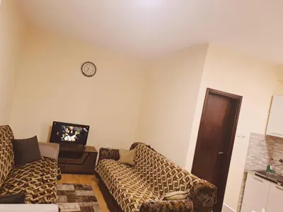 a living room with two couches and a clock on the wall at Prestige 4 in Podgorica