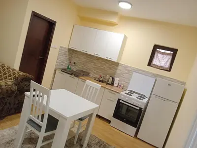 a kitchen with a table and a white table and chairs at Prestige 4 in Podgorica