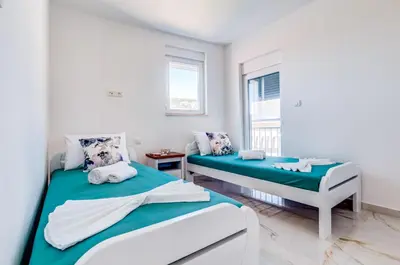 a bedroom with two beds and a window at Villa Hanna Apartments in Sutomore