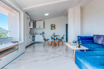 a living room with a blue couch and a table at Villa Hanna Apartments in Sutomore