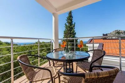 a patio with a table and chairs on a balcony at Villa Hanna Apartments in Sutomore