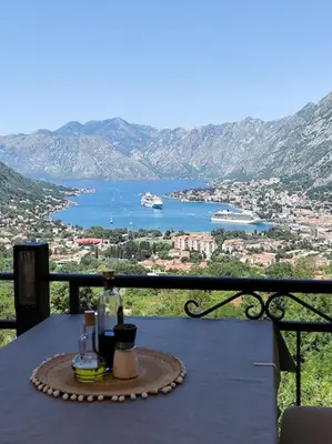 a table with a bottle of wine on top of a balcony at Vidikovac in Kotor
