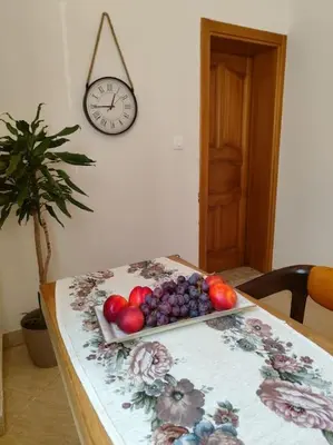 a table with a plate of fruit on it with a clock at Vidikovac in Kotor