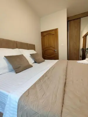 a large white bed with two pillows on it at Vidikovac in Kotor