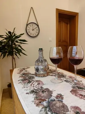 two glasses of wine on a table with a clock at Vidikovac in Kotor