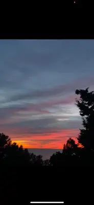 a sunset in the sky with trees in the foreground at Šušanj dvokrevetna soba in Bar, Susanj