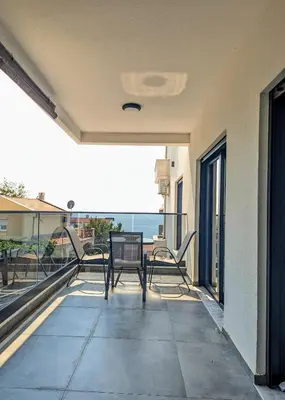 a patio with chairs and a table on a balcony at Dea apartment in Dobra Voda