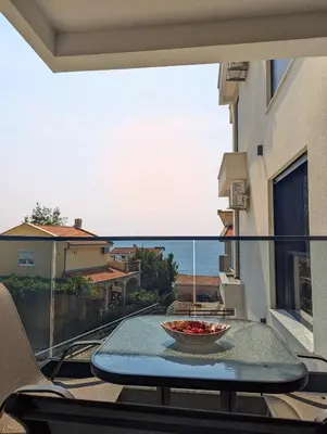 a balcony with a table and a view of the ocean at Dea apartment in Dobra Voda