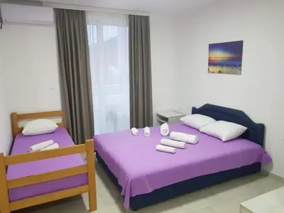 a bedroom with two beds with purple sheets and towels at Villa MARINA CANJ 2 in Čanj