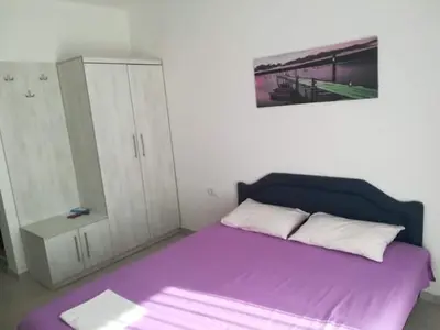 a bedroom with a purple bed and a cabinet at Villa MARINA CANJ 2 in Čanj