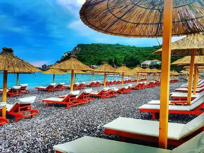 a beach with chairs and umbrellas and the ocean at Villa MARINA CANJ 2 in Čanj
