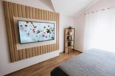a bedroom with a flat screen tv on a wall at Apartments Podgorička Vila in Podgorica
