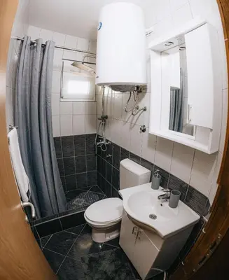a bathroom with a toilet and a sink and a mirror at Apartments Podgorička Vila in Podgorica