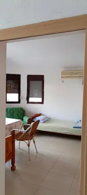 a room with a bed and a chair and a table at Apartmani Kolovic Susanj in Bar