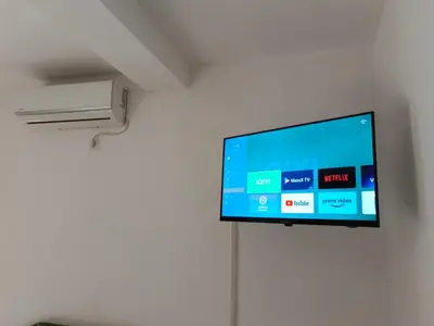 a flat screen tv hanging on a wall at Apartmani Kolovic Susanj in Bar
