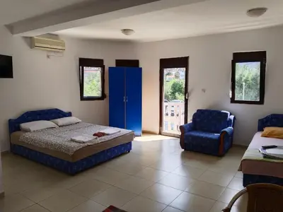 a bedroom with a bed and a blue cabinet and a chair at Apartmani Kolovic Susanj in Bar