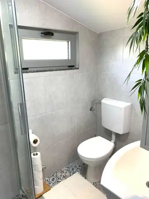 a bathroom with a toilet and a sink and a window at Markovic Village Apartments in Ulcinj