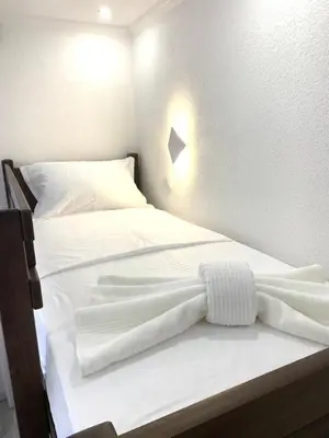 two beds in a room with white sheets at Markovic Village Apartments in Ulcinj
