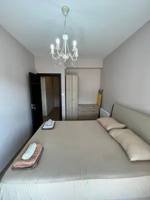 a bedroom with a large bed with a chandelier at Fazenda 2 Becici in Becici