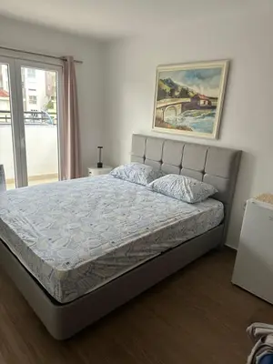 a bed in a bedroom with a painting on the wall at Apartman MONTE Sea BEČIĆI in Becici