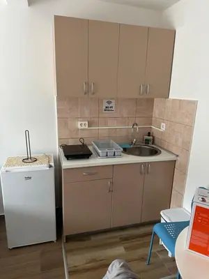 a small kitchen with a sink and a refrigerator at Apartman MONTE Sea BEČIĆI in Becici