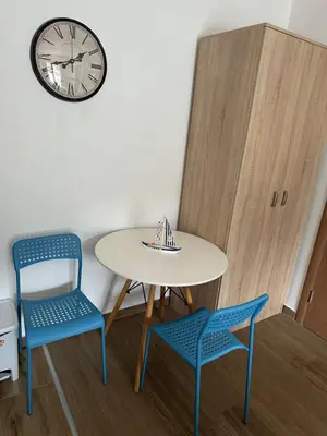 a table and two chairs and a clock on a wall at Apartman MONTE Sea BEČIĆI in Becici