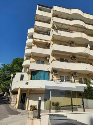 a tall apartment building with balconies on a street at Apartman MONTE Sea BEČIĆI in Becici