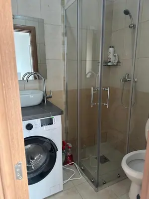 a bathroom with a shower and a washing machine at Apartman MONTE Sea BEČIĆI in Becici