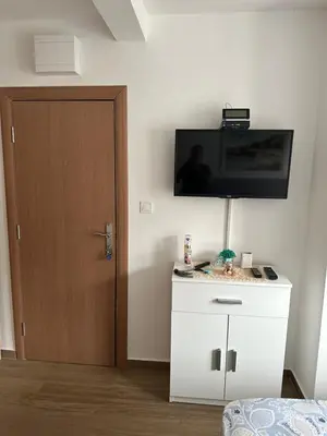 a room with a tv on the wall and a door at Apartman MONTE Sea BEČIĆI in Becici