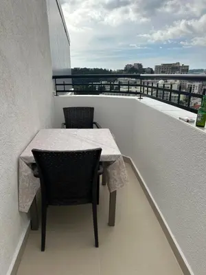 a table and chairs on a balcony with a view at Apartman MONTE Sea BEČIĆI in Becici
