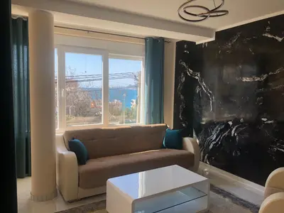 a living room with a couch and a large window at BonMare.apt4 in Dobra Voda