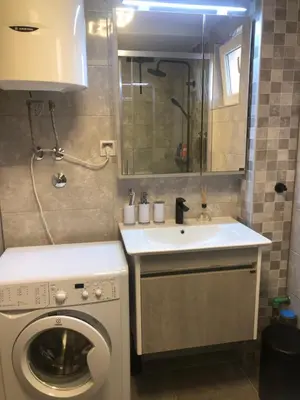 a bathroom with a washing machine and a sink at BonMare.apt4 in Dobra Voda
