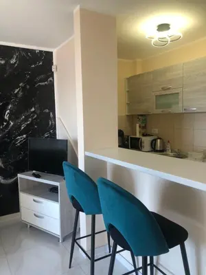 a kitchen with two blue chairs and a counter at BonMare.apt4 in Dobra Voda
