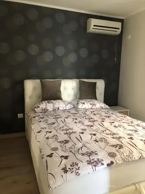 a bedroom with a bed with a white comforter at BonMare.apt4 in Dobra Voda