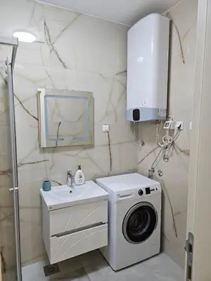 a bathroom with a washing machine and a sink at Montedream apartments in Bar