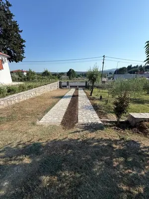 a long pathway with a stone wall and a bench at Casa Hollaj in Vladimir