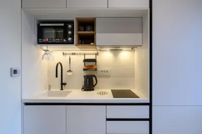 a kitchen with white cabinets and a sink at Modular Sea view Spa Studio in Kotor