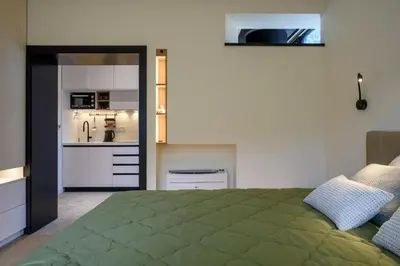 a bedroom with a green bed and a kitchen at Modular Sea view Spa Studio in Kotor