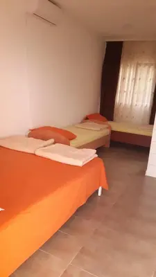 two beds in a room with orange sheets at Panorama in Čanj