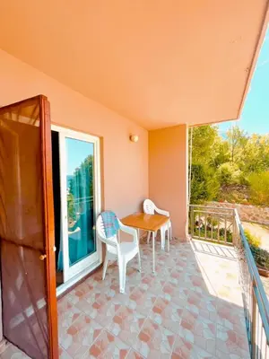 a porch with a table and chairs on a balcony at Panorama in Čanj