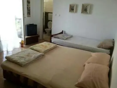 two twin beds in a room with a television at Panorama in Čanj